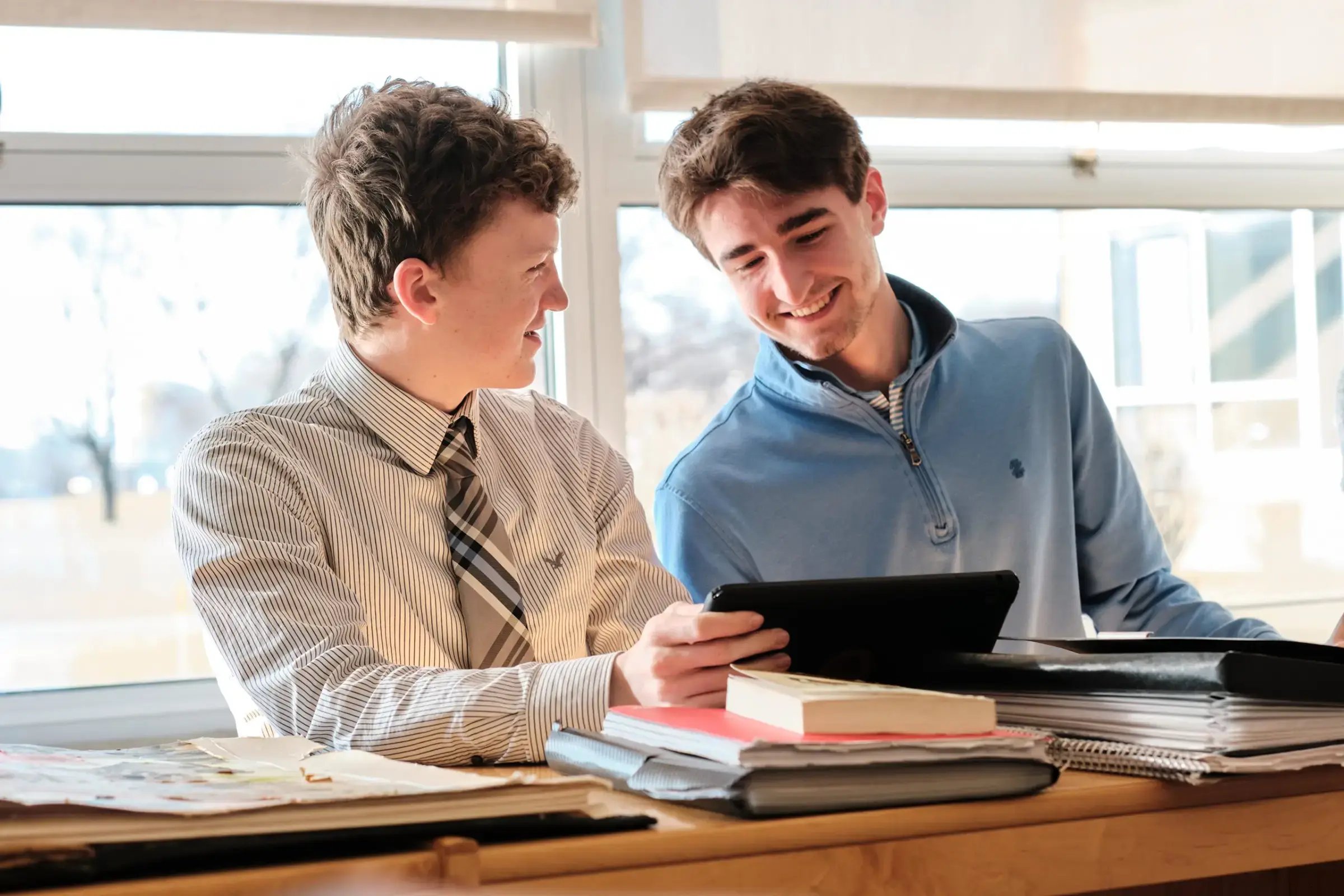 Two boys using tablet together and smiling